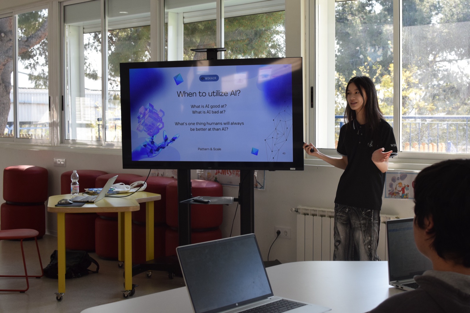 A Wikair volunteer presenting “When to utilize AI?” on a classroom screen